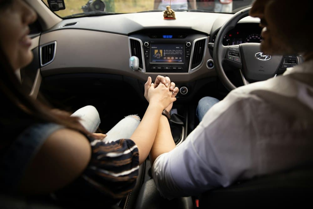 Two people holding hands in a car